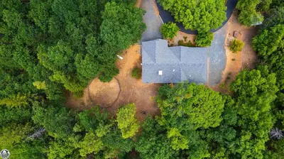 an aerial view of a house in the middle of a forest at Sierra Haus Cottage with Private Lake Access in Sonora