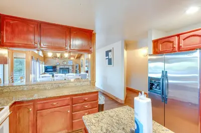 a kitchen with wooden cabinets and a stainless steel refrigerator at Game Rooms, Sauna and Decks South Lake Tahoe Home in South Lake Tahoe