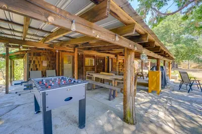 a wooden house with a ping pong table in front of it at Rustic Cabin with Patio 8 Mi to Kings Canyon Park in Miramonte