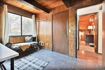 a room with a bed and a window and a door at Hathaway Pines Hideaway Chalet in Hathaway Pines