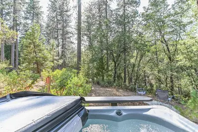 a hot tub in the middle of the woods at Hathaway Pines Hideaway Chalet in Hathaway Pines