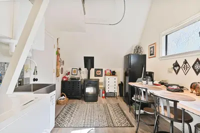a kitchen with a refrigerator and a table with chairs at Hathaway Hideaway Loft Apartment in Hathaway Pines