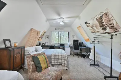 a bedroom with a bed and a desk in a room at Hathaway Hideaway Loft Apartment in Hathaway Pines