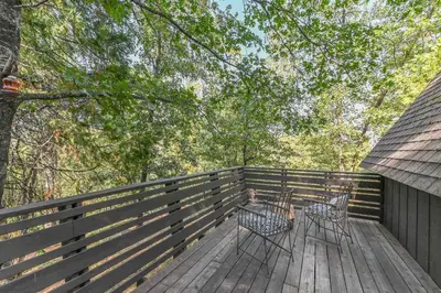 two chairs on a deck with a fence at Hathaway Hideaway Loft Apartment in Hathaway Pines
