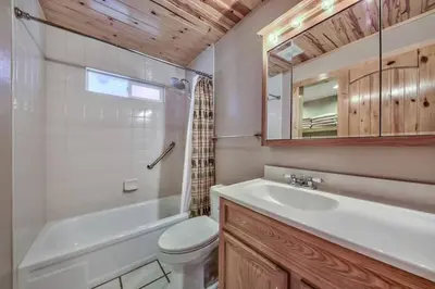 a bathroom with a sink and a toilet and a bath tub at Tahoe Townie - Cozy Cabin in South Lake Tahoe! in South Lake Tahoe