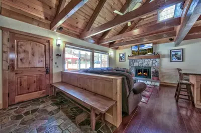 a living room with a bench and a fireplace at Tahoe Townie - Cozy Cabin in South Lake Tahoe! in South Lake Tahoe