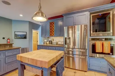 a kitchen with blue cabinets and a wooden table at Elegant 6 Bed Sleeps 14 - Best for families w kids in South Lake Tahoe