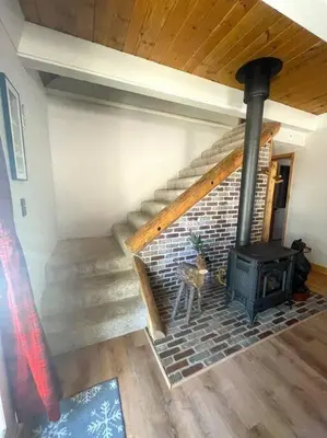 a living room with a brick fireplace and stairs at Moose Haven - Family Favorite! Close to beaches! in South Lake Tahoe