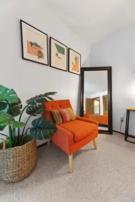 an orange chair in a room with a mirror at Sequoia Zen River House in Three Rivers