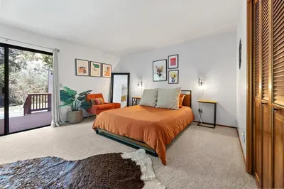 a bedroom with a bed with an orange bedspread at Sequoia Zen River House in Three Rivers