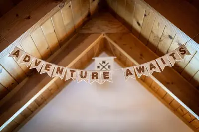 a sign that says adventure awaits hanging from a ceiling at Panorama Chalet - Hot tub - Pool Table - Snow in Nebelhorn