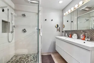 a white bathroom with a shower and a sink at Mountain Pine Memories - Dogs - Hot tub - E-bikes in South Lake Tahoe