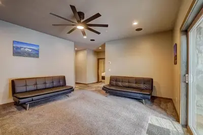 two leather couches in a room with a ceiling fan at Chateau de Navahoe - Luxury - Hot tub - Large yard in South Lake Tahoe
