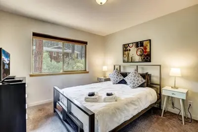 a bedroom with a large bed and a window at Sierra Solace - Forest & Seasonal River Out Back in South Lake Tahoe