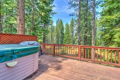 a wooden deck with a grill on top of it at Tahoe Tranquility - Dogs - Hot tub - Ping Pong in South Lake Tahoe