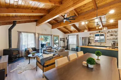 a living room with a wooden ceiling and a table at Guadalupe Getaway - Pets - Hot Tub - AC in South Lake Tahoe