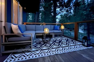 a patio with a couch and a table on a deck at Guadalupe Getaway - Pets - Hot Tub - AC in South Lake Tahoe