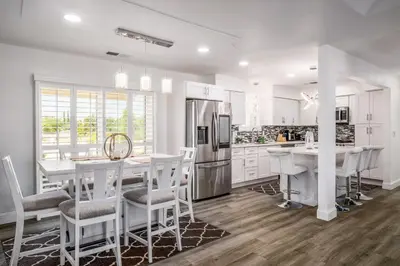 a kitchen with white cabinets and a table and chairs at Remodeled 1 Acre Ranch Home in Madera in Madera