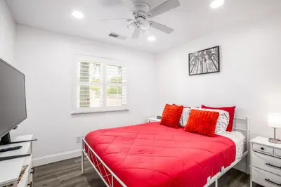 a bedroom with a red bed with a ceiling fan at Remodeled 1 Acre Ranch Home in Madera in Madera