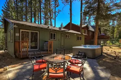a patio with a table and chairs in front of a house at Bear Cub Cabin - Pets - Hot tub - Arcade Game in Mevers
