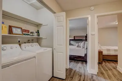 a white laundry room with a sink and a bed at Bear Cub Cabin - Pets - Hot tub - Arcade Game in Mevers