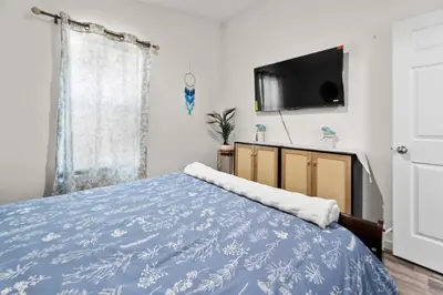 a bedroom with a blue bed with a tv on the wall at 10 Min Drive to the Sequoias in Three Rivers