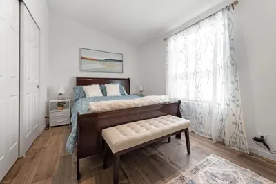 a bedroom with a bed with a bench and a window at 10 Min Drive to the Sequoias in Three Rivers