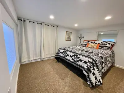 a bedroom with a bed with a black and white comforter at Waterfront Home w 40x16 Berth in Bethel Island