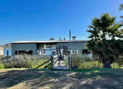a building with a palm tree in front of it at Waterfront Home w 40x16 Berth in Bethel Island