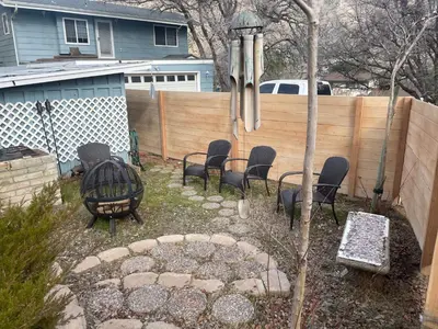 a backyard with chairs and a table and a fence at Mountain View Home in Kernville