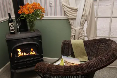 a room with a chair and a fireplace at McCaffrey House Bed and Breakfast Inn in Twain Harte