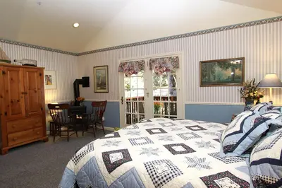 a bedroom with a bed with a blue and white quilt at McCaffrey House Bed and Breakfast Inn in Twain Harte
