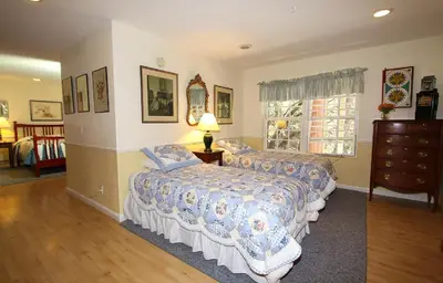 a bedroom with two beds and a dresser and a window at McCaffrey House Bed and Breakfast Inn in Twain Harte