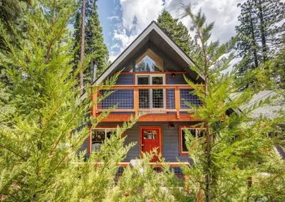 a cabin in the trees with a red door at Hot tub - Play structure - Mini pool table game in South Lake Tahoe