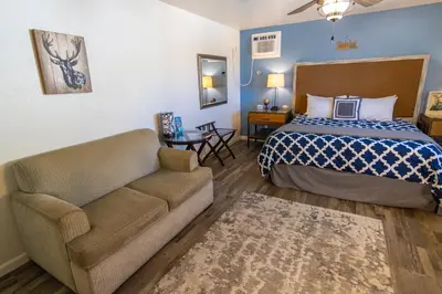 a hotel room with a bed and a couch at Creature Comforts Suite-Private Hot Tub-Sleeps 2 in Ahwahnee