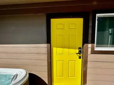 a yellow door on a house with a building at Creature Comforts Suite-Private Hot Tub-Sleeps 2 in Ahwahnee
