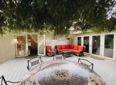 a patio with a red couch and a table at Redwood Garden in Sacramento