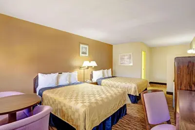 a hotel room with two beds and a table and chairs at Howard Johnson by Wyndham South Lake Tahoe in Bijou