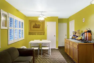a living room with a table and a kitchen with yellow walls at Howard Johnson by Wyndham South Lake Tahoe in Bijou