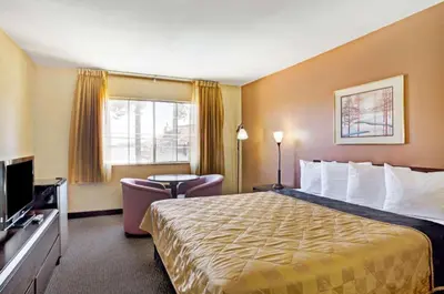 a hotel room with a large bed and a chair at Howard Johnson by Wyndham South Lake Tahoe in Bijou