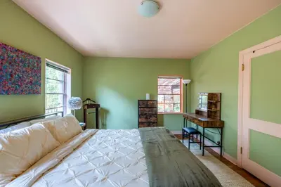 a bedroom with green walls and a bed and a desk at Cozy 2BR Home Near UNR with Large Deck & Parking in Reno