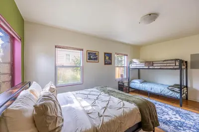 a bedroom with a bed and bunk beds in it at Cozy 2BR Home Near UNR with Large Deck & Parking in Reno