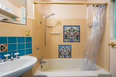 a bathroom with a tub and a sink at Cozy 2BR Home Near UNR with Large Deck & Parking in Reno