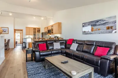 a living room with a leather couch and a table at Snowcreek #793 Phase V - 3 Bedroom 3 Bath Sleeps 8 with Private 1 Car Garage in Mammoth Lakes
