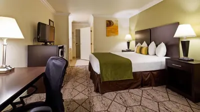 a hotel room with a bed and a desk at Best Western Executive Inn in Los Banos