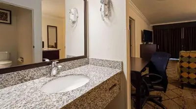 a bathroom with a sink and a mirror at Best Western Executive Inn in Los Banos