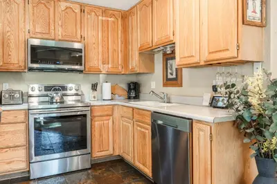 a kitchen with wooden cabinets and a stainless steel appliance at Sierra Park Villas #76, Updated 1 Bedroom + 2 Lofts, 2 Bath, Sleeps 6! in Mammoth Lakes