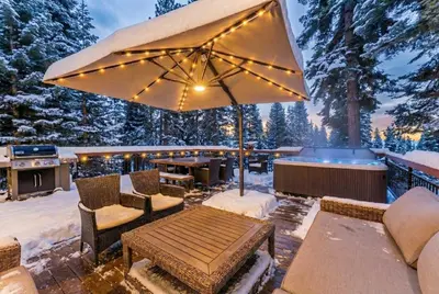 a patio with a table and chairs and an umbrella at Modern Mountain Luxury Retreat, Hot Tub & Grill in Carnelian Bay