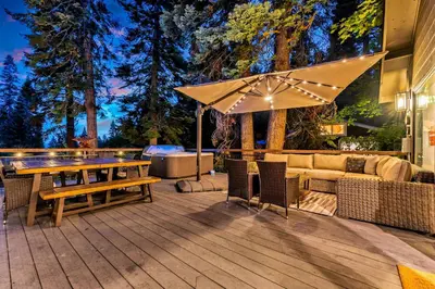 a patio with a table and a couch and an umbrella at Modern Mountain Luxury Retreat, Hot Tub & Grill in Carnelian Bay