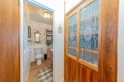 a bathroom with a toilet and a wooden door at Sunset Summit Villa 2 min from Bass Lake in Bass Lake